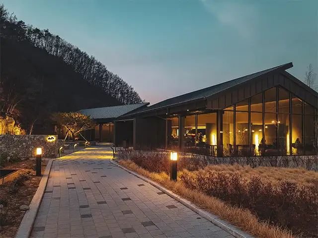 Energy Storage Battery Applications Modern lodge lit at dusk with pathway lights, an example of off-grid energy storage use